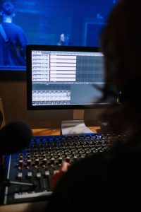 pexels photo 5657671 A recording artist working on audio mixing at a sound studio workstation.