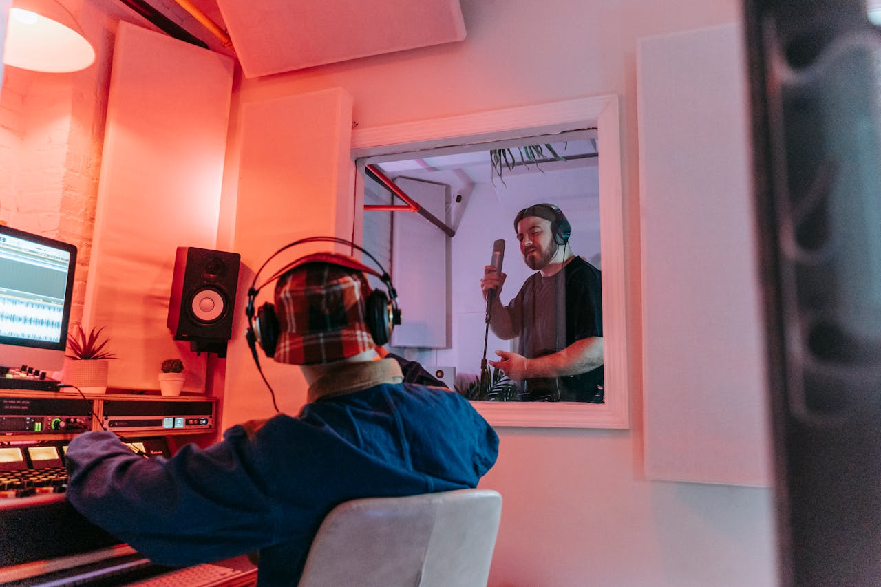Audio engineer and singer collaborating in a modern recording studio environment.